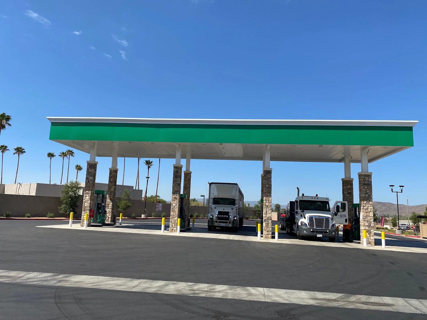 Semi trucks fueling under the Roadside Oasis truck stop canopy